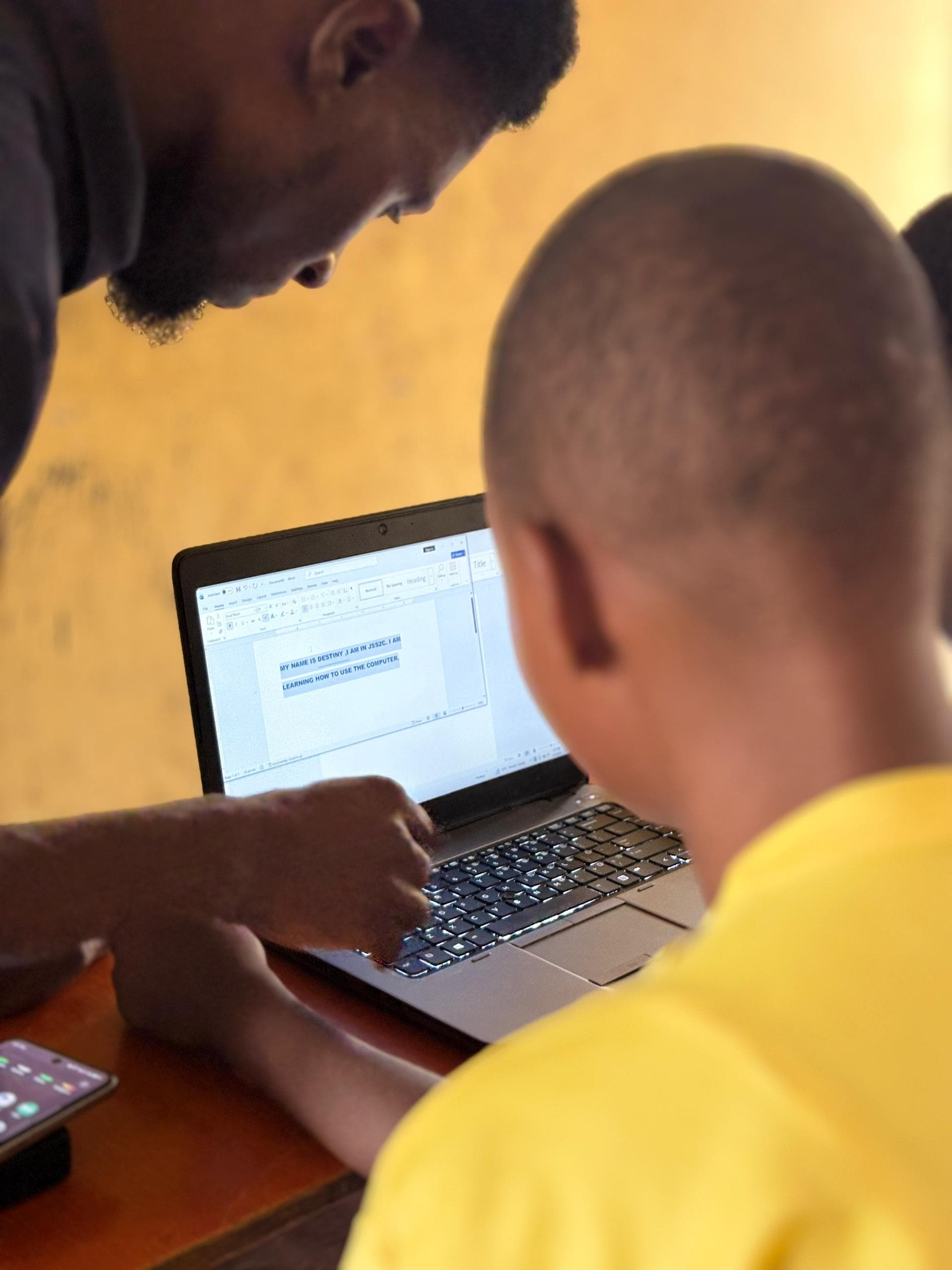 A volunteer guiding a community member through a digital skills lesson